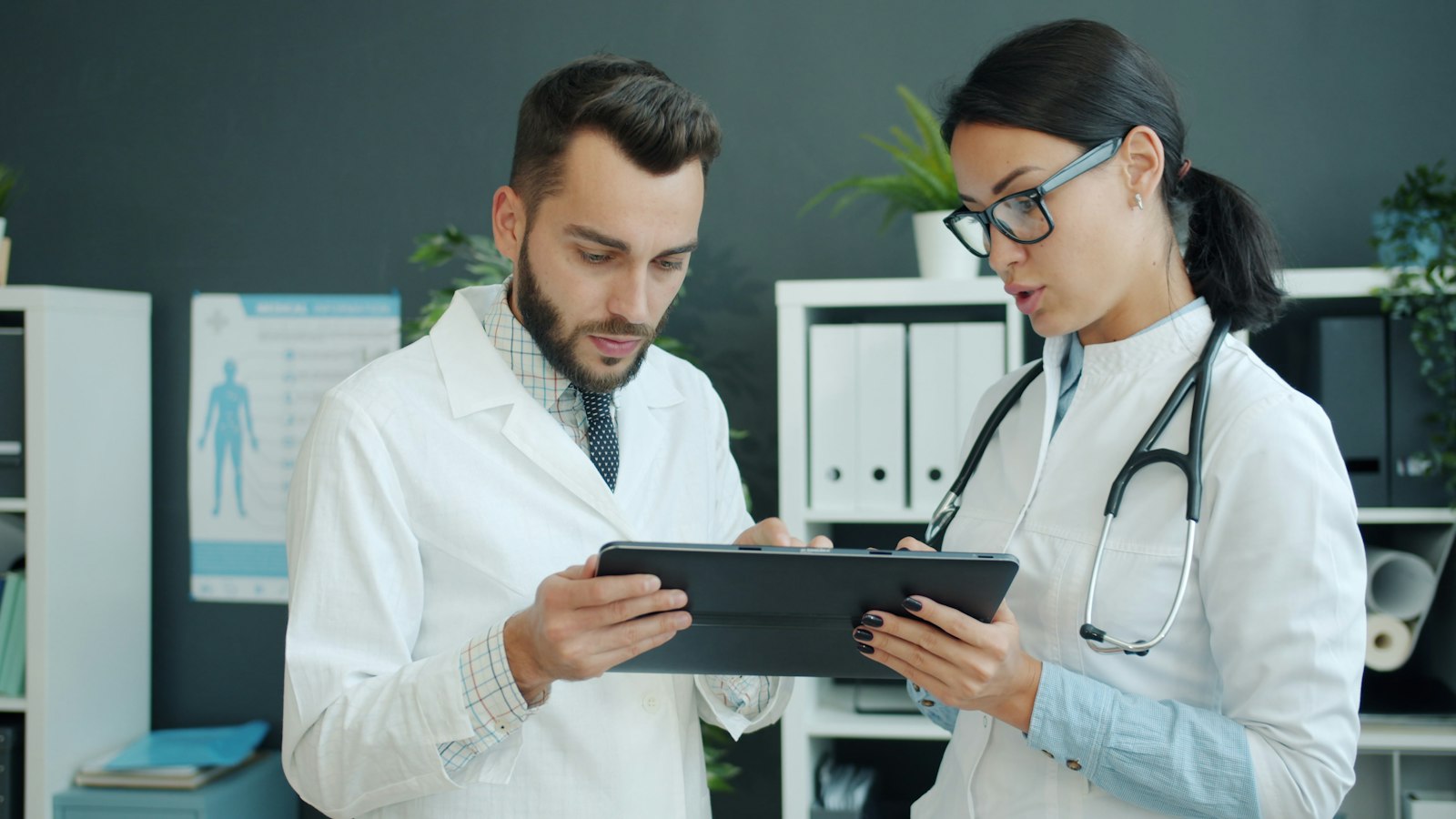 Two clinicians reviewing information on a tablet